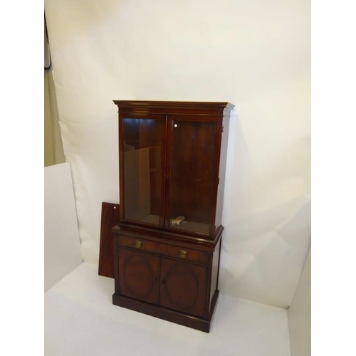 213 - An American mahogany side cabinet, the upper section having glazed doors, the base with a long drawe... 