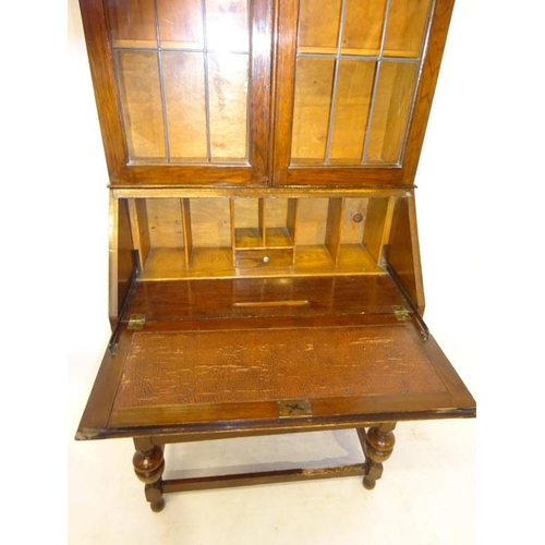 35 - An Edwardian oak bureau bookcase with presentation plaque, the upper section with leaded glass doors... 