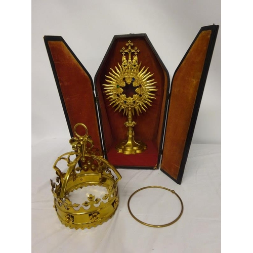 63 - A gilded Monstrance with carrying case and a brass shaped crown. (2)