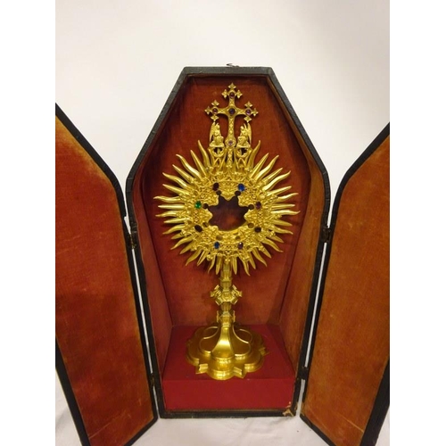 63 - A gilded Monstrance with carrying case and a brass shaped crown. (2)