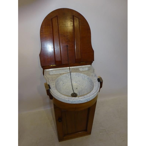 70 - A Victorian ship's washstand, the mahogany case having a shaped top and fitted with a china washbasi... 