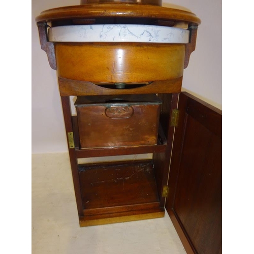 70 - A Victorian ship's washstand, the mahogany case having a shaped top and fitted with a china washbasi... 