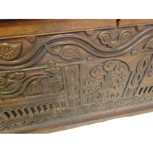 75 - A large antique oak coffer, the front panel extensively carved and dated 1902 more likely made for t... 