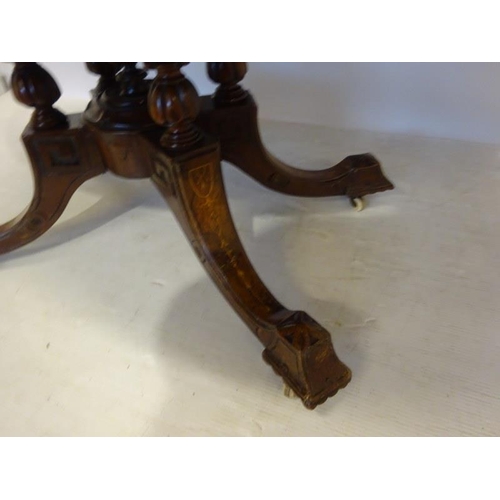 77 - A Victorian inlaid and figured walnut drawing room table, the oval top on centre pod support having ... 