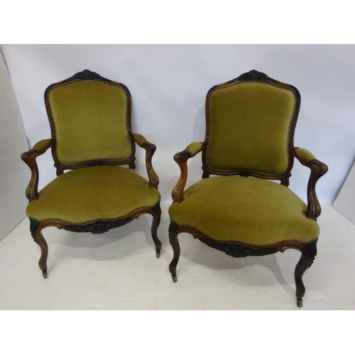 80 - A pair of antique French carved rosewood drawing room easy chairs having open arms and raised on cab... 