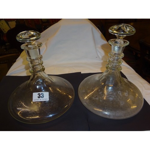 33 - A pair of ships glass decanters and stoppers with engraved decoration.