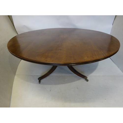 104 - A large antique mahogany circular dining room table on centre pod support with brass toe castors. 
W... 