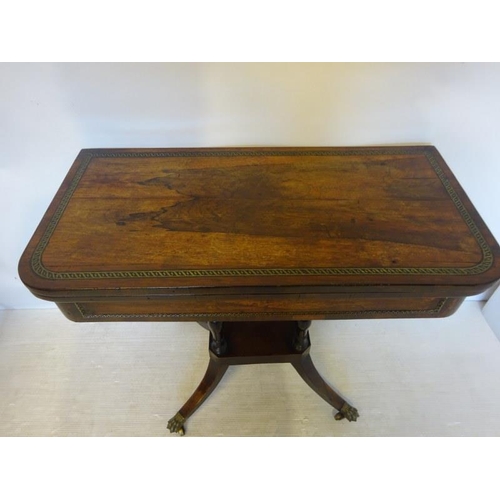 112 - A Regency rosewood and brass inlaid card table raised on turned columns platform base with four spla... 