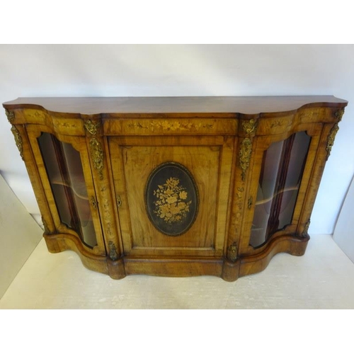 130 - A good Victorian walnut credenza, the side doors with shaped glass panels, the centre door with oval... 