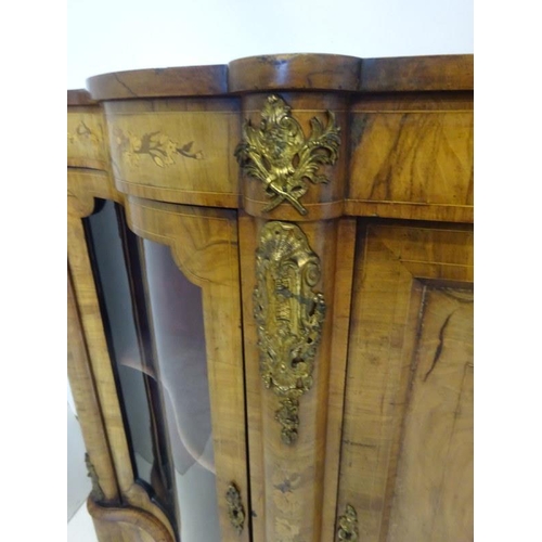 130 - A good Victorian walnut credenza, the side doors with shaped glass panels, the centre door with oval... 