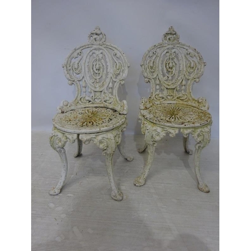 202 - A pair of heavy antique cast iron garden chairs.