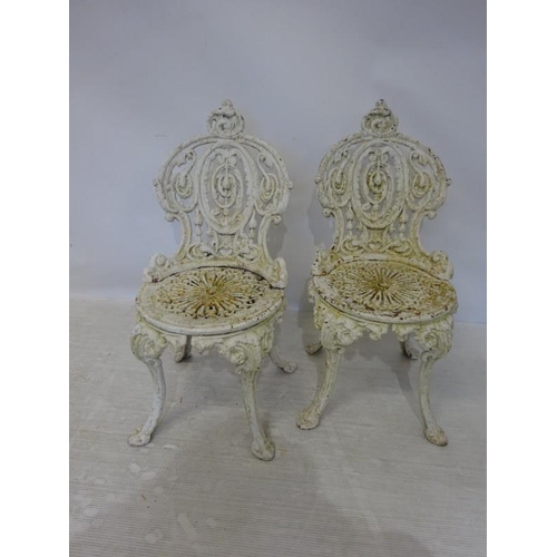 202 - A pair of heavy antique cast iron garden chairs.