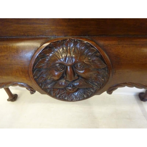 280 - An Irish Edwardian mahogany side table, the rectangular top over shaped freized with carved head dec... 