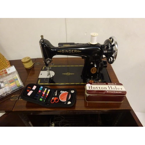 337 - An electric singer sewing machine house in a cabinet with numerous accessories.