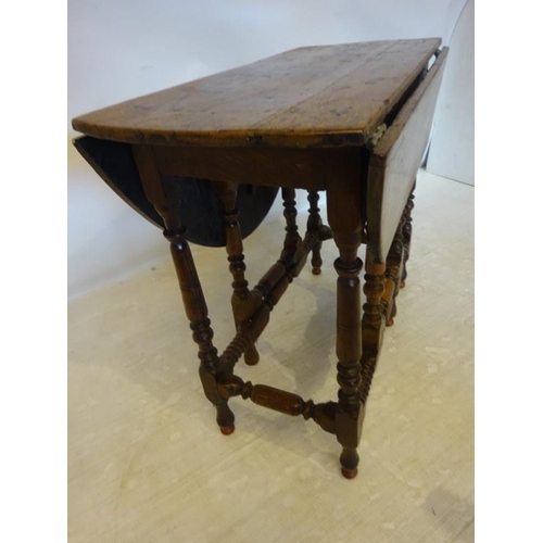 41 - Early antique oak drop leaf table raised on turned legs with cross stretchers. L. 86cm closed, 107cm... 