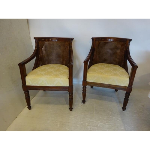 68 - A pair of mahogany framed drawing room easy chairs with bergere backs and drop in seats.