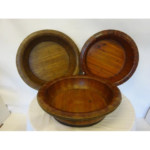 70 - Four large old brass banded timber bowls, one needing attention. Diameter 80cm approx.