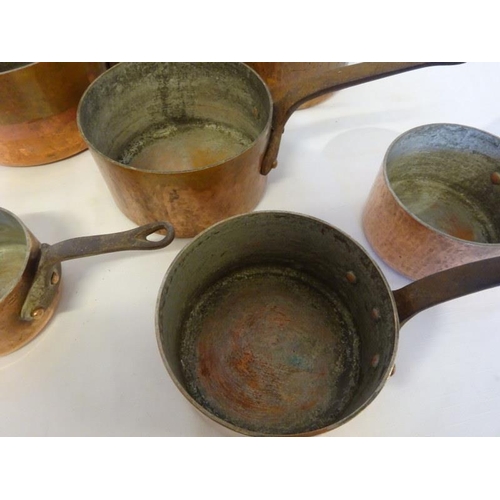 83 - Six heavy copper saucepans with iron handles.