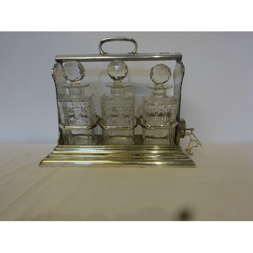 275 - A silver plated tantalus with three cut glass decanters.