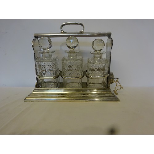 275 - A silver plated tantalus with three cut glass decanters.