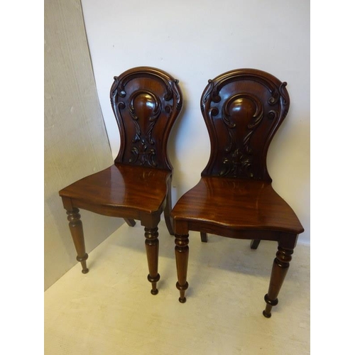 101 - A pair of good quality Victorian mahogany hall chairs having nicely carved backs, shaped seats and t... 