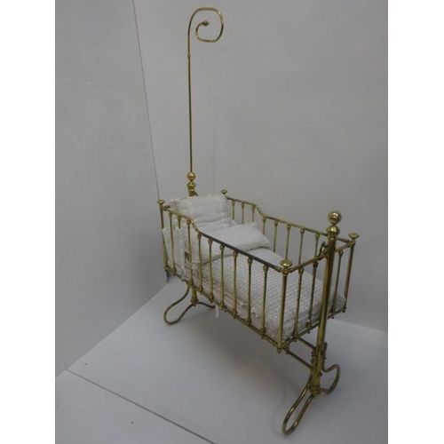 129 - An antique brass swinging cot.