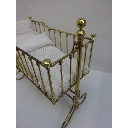 129 - An antique brass swinging cot.