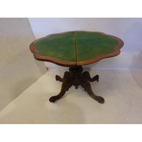 131 - A Victorian figured walnut card table, the shaped folding top on carved and turned column with four ... 