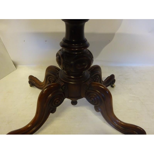 131 - A Victorian figured walnut card table, the shaped folding top on carved and turned column with four ... 