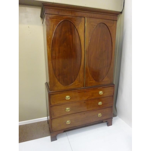 143 - Georgian mahogany linen press, the upper section having two doors with oval panels opening to reveal... 