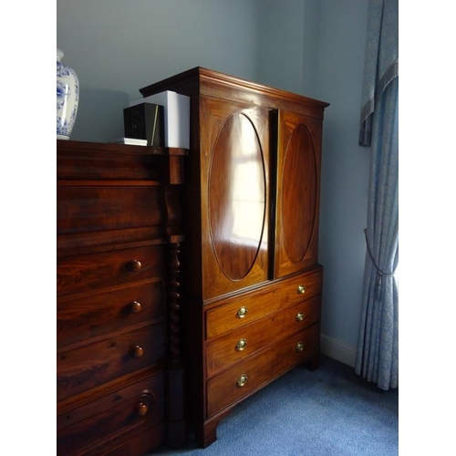 143 - Georgian mahogany linen press, the upper section having two doors with oval panels opening to reveal... 