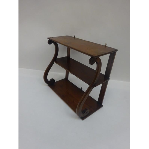 145 - A 19th century mahogany hanging shelves on scroll supports. Overall height 47cm, W. 54cm, D. 23cm. a... 