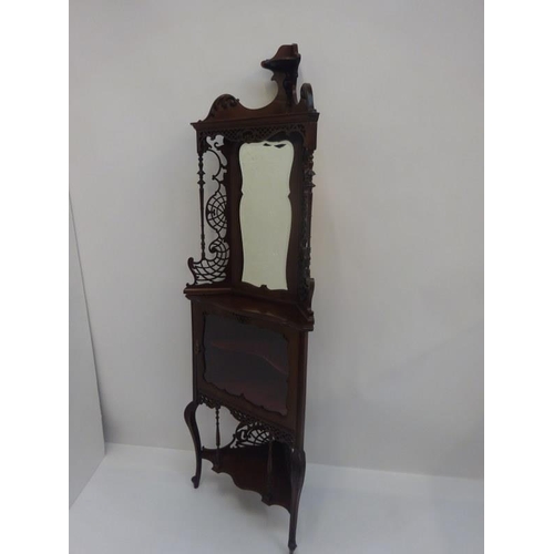 147 - An Edwardian carved mahogany and mirror back corner cabinet. H. 200cm approx.