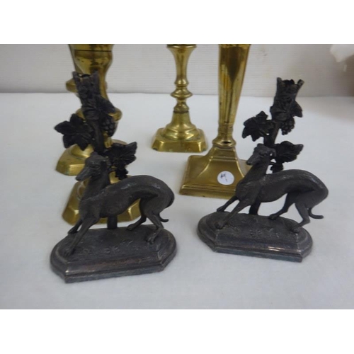 2 - Four old brass candlesticks and two greyhound fireplace ornaments (possibly lacking glass flutes). (... 