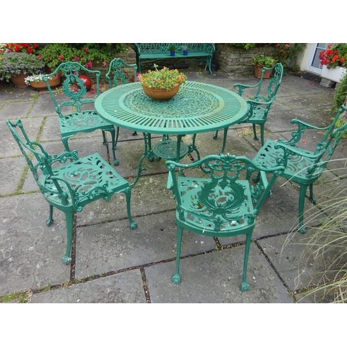 245 - An aluminum circular garden table with four carvers and two single chairs.