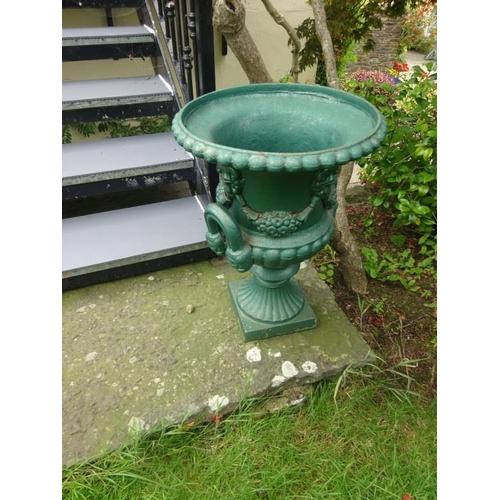 262 - A good pair of cast iron urns having mask and loop handles and scrolling foliage raised on square ba... 