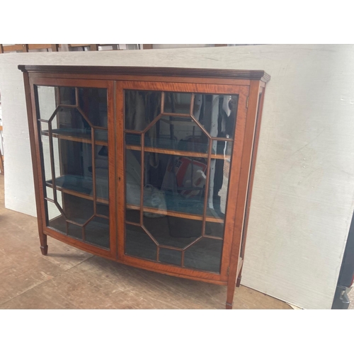 280 - A good antique satinwood bow shaped drawing room cabinet.