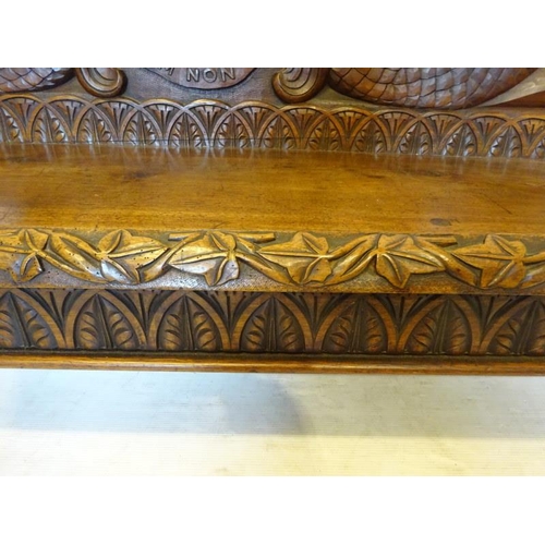 306 - An antique carved walnut hall bench, the back with a central heraldic sheild carved Nun Quam Non Par... 