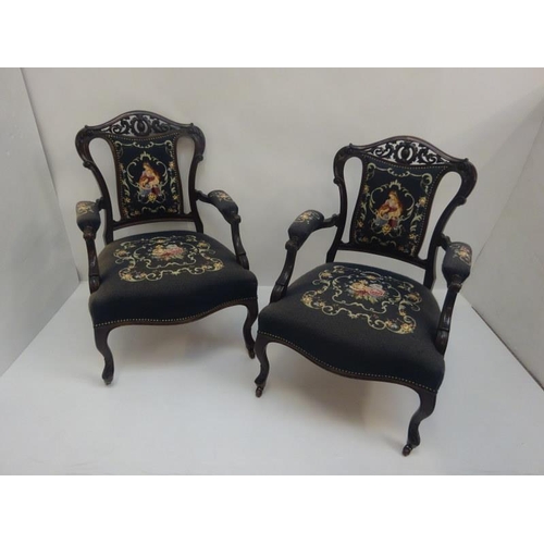 309 - A pair of late 19th century carved mahogany open arm drawing room chairs with needlework upholstery.