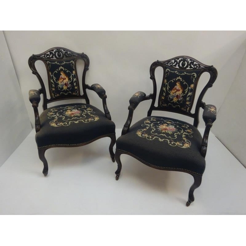 309 - A pair of late 19th century carved mahogany open arm drawing room chairs with needlework upholstery.