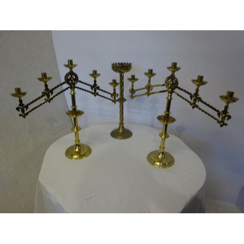 312 - A pair of adjustable church brass altar candlesticks and a single candlestick. (3)