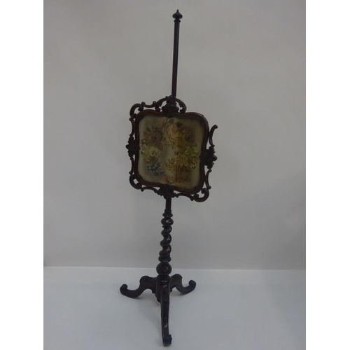 315 - Victorian carved mahogany pole screen having needlework panel and raised on tripod base.