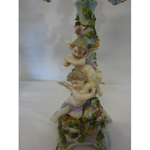 321 - A pair of 19th century continental porcelain candleabra surmounted with cherubs and floral decoratio... 