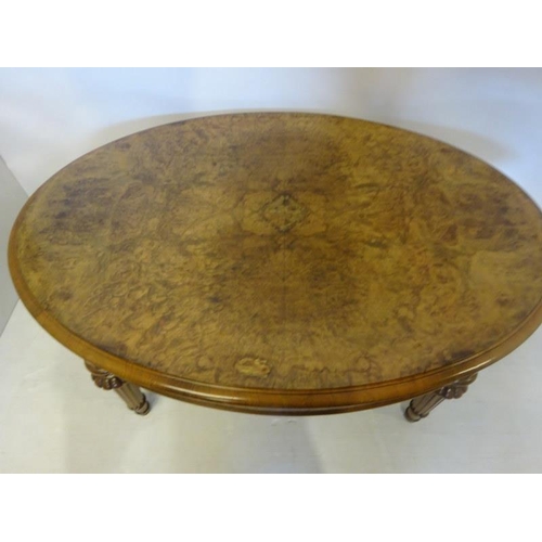 67 - A Victorian walnut coffee table, the oval shaped top raised on fluted tapering legs. L. 120cm, W. 86... 