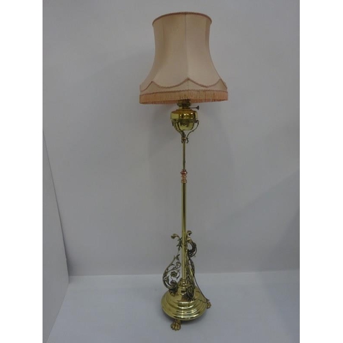 94 - A good Victorian brass standard lamp and shade on circular base with claw feet.