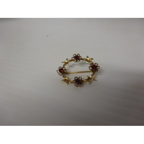 290 - 9 carat gold brooch with garnet style stones.