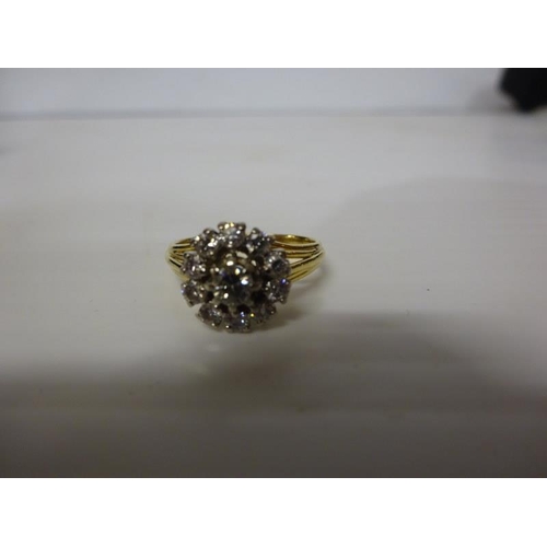 293 - 18 carat gold diamond cluster ring having a round cut diamond surrounded by an open cluster of 10 cu... 