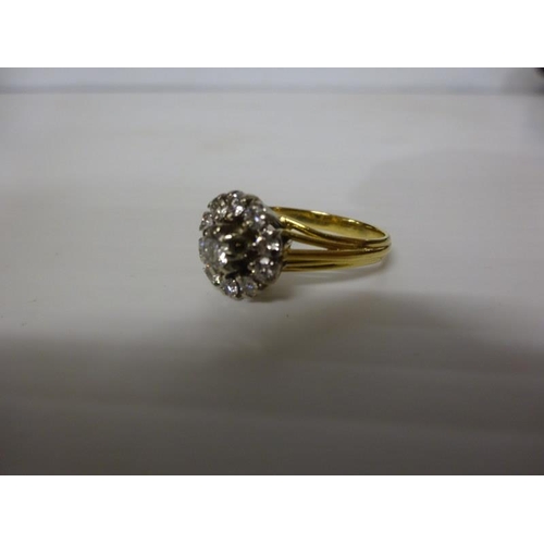 293 - 18 carat gold diamond cluster ring having a round cut diamond surrounded by an open cluster of 10 cu... 