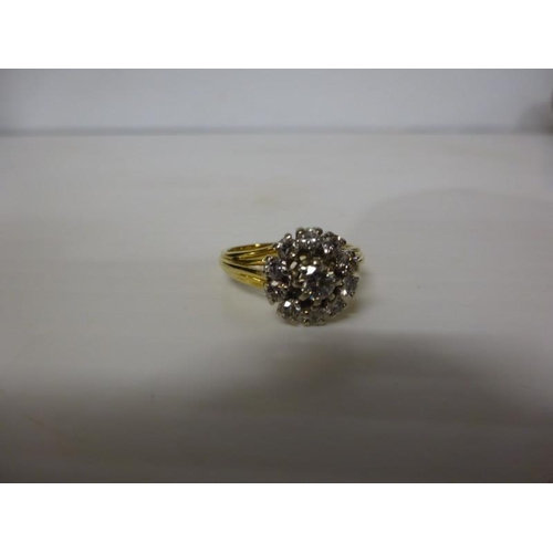 293 - 18 carat gold diamond cluster ring having a round cut diamond surrounded by an open cluster of 10 cu... 