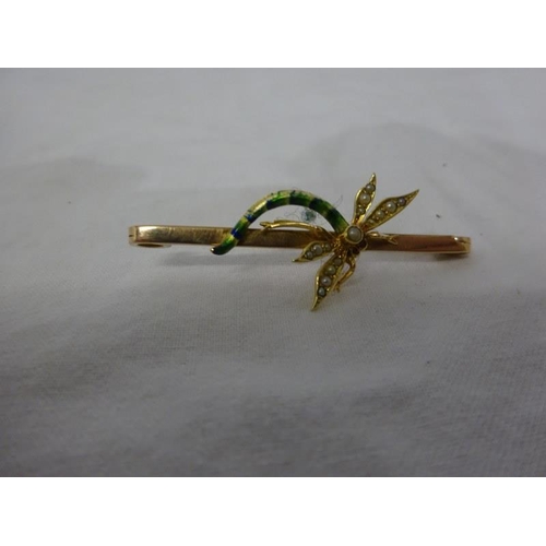 297 - Three gold brooches - one dragonfly, one hockey stick and a pearl brooch.